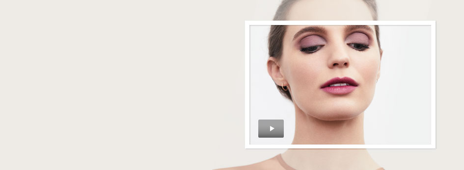 Get the step-by-step application tips for creating the season’s on-trend Just-Bitten Lip Look from Mary Kay. A woman with brown hair is seen on the right side wearing pink and purple eye shadow with a light pink and purple lipstick. 