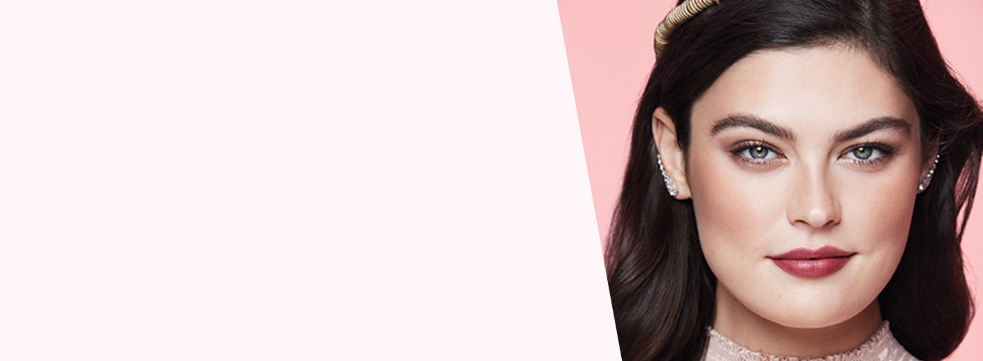 Model wearing Roman Sunrise makeup artist look from Mary Kay against pink background.