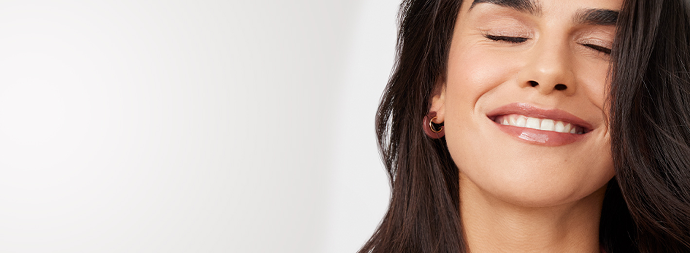 Close up of model with closed eyes and relaxed smile wearing the Laid-Back Beauty makeup artist look