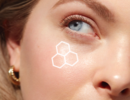 Up close macro image of a blonde white woman showing a corner of her face including her eyebrow, one blue eye and her nose with an outline of the TimeWise 3D Complex on her cheek