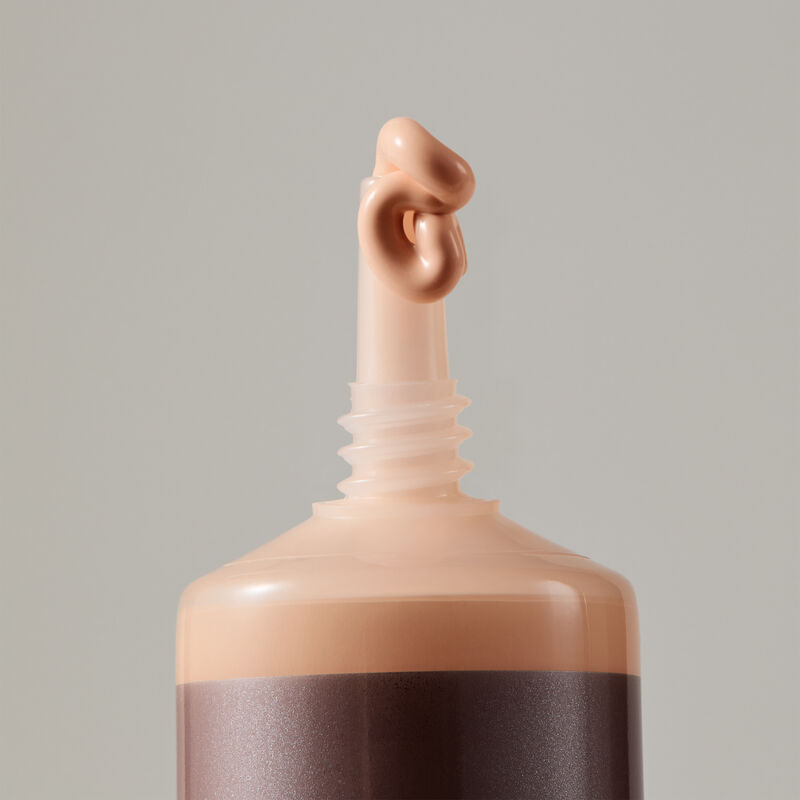 Macro view of TimeWise Luminous 3D Foundation needlenose applicator dispensing Light 2 shade
