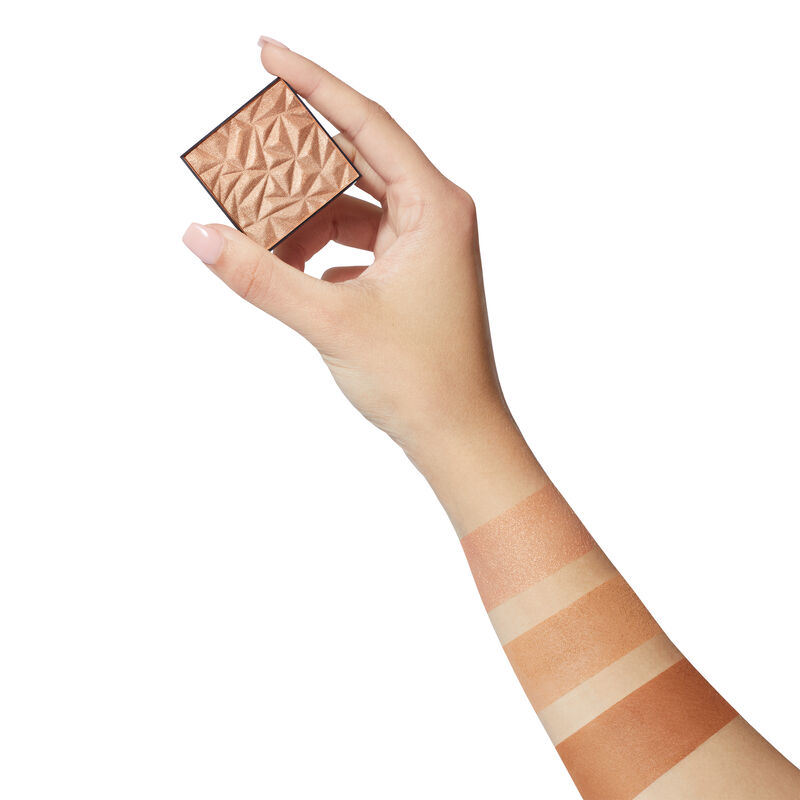 Fair-skinned hand holding limited-edition Mary Kay Illuminating Highlighter