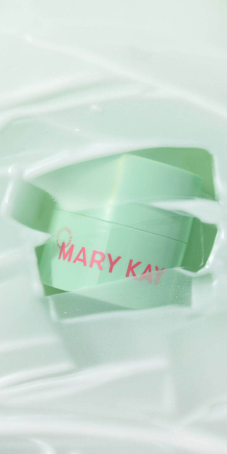 Profile view of woman with fun earrings and hairclips applying Mary Kay Unlimited Lip Gloss 