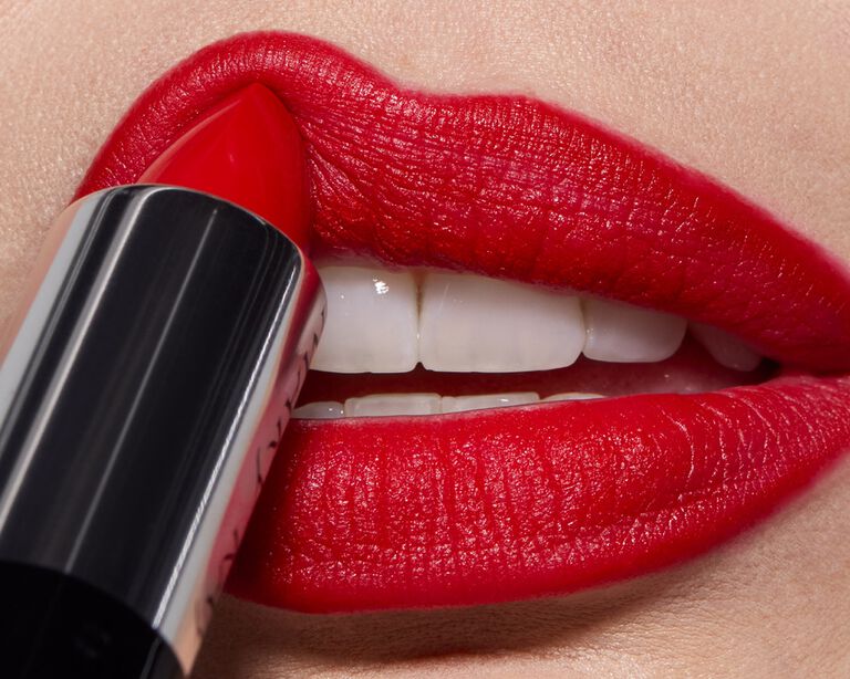 Aplic&aacute;ndose labia rojo en los labios