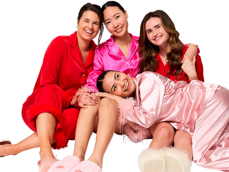 Mujeres sentadas abraz&aacute;ndose y riendo.
