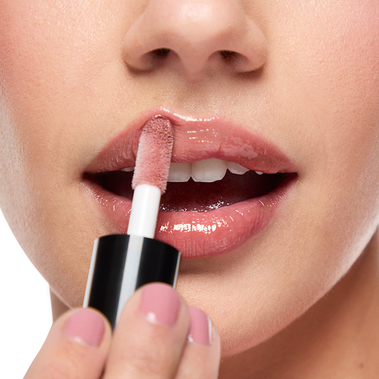 Woman applying Mary Kay Lip Oil in shade Blush